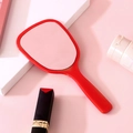 Elegant handheld makeup mirror in vibrant red finish on a soft pink background - Red