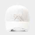 Dettaglio cappellino bianco con fiocco di perle e finiture in pizzo elegante - Regolabile / Bianco