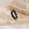 Minimalist black stainless steel ring with a polished finish on a stone display - Size 6 / Black Plain 4mm