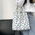 Floral canvas tote bag with blue berry print shown being carried by a model - Blue Purple Berries