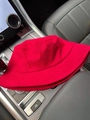 Detailed texture of a red corduroy bucket hat displayed on a car dashboard - Adjustable / Red