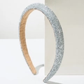 Elegante diadema de purpurina plateada sobre un soporte geométrico blanco de estilo minimalista - Blanco