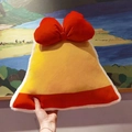 Close-up of yellow bell-shaped plush pillow with large red bow and white faux fur trim - Christmas Bell