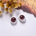 Dettaglio macro di occhi rossi in acrilico per bambole 12x16mm su carta vintage - Rosso Venato di Sangue