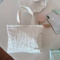 Primer plano del bolso de tela jacquard blanco con etiqueta bordada y relieve floral - Blanco