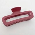 Close-up of matte wine red rectangular hollow hair claw clip on textured beige fabric - Large (13CM) / Carmine