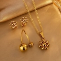 Elegantes Set aus goldener Blumenkette, Ohrsteckern und offenem Ring auf Goldener Seide - Perlenset
