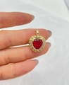 Vue macro d'un pendentif cœur plaqué or avec pierre rouge et halo de zircons brillants - Or+Rouge