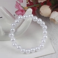 Witte imitatie parelarmband voor kinderen gepresenteerd op een keramisch handmodel - 8MM Witte Parelarmband