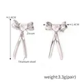 Polished silver titanium steel bow earrings with heart-shaped zircon center stones - Steel White Zircon Bow (F1474)