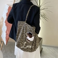Leopard-Canvas-Tote mit Hunde-Stickerei in einer stilvollen Lifestyle-Szene getragen - Brauner Leopard Mit Besticktem Hund