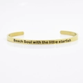 Dettaglio del bracciale rigido dorato 4mm in acciaio inox con incisione Beach Soul - Anima da spiaggia con la piccola stella marina