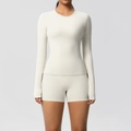 Detail of long sleeve yoga top and high waist shorts set in creamy white athletic fabric - Light Ivory