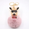 Dettaglio del portachiavi bulldog francese con testa dorata e pompon di peluche rosa - colore fagiolo rosso