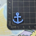 Macro shot of a light blue anchor charm next to a ruler showing its 2cm small size - Anchor