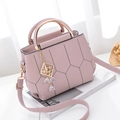 Gesteppte Handtasche in Altrosa mit goldenen Griffen und Kristallanhänger auf Magazin - Lila