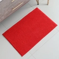 Absorbent red chenille bath mat with non-slip texture on beige tile floor - Red