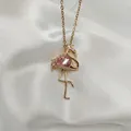 Macro shot of flamingo pendant featuring a pink pear-cut stone and pavé zircon details - Gold