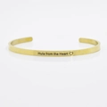 Golden stainless steel cuff bracelet engraved with Hula from the Heart text and heart symbol - Hula from the Heart
