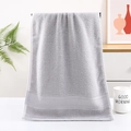 Asciugamano in cotone grigio chiaro con bordo a trama in un bagno in stile moderno - Grigio Con Motivo A Nido D'ape