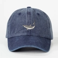 Detailed embroidery of a great white shark on a washed blue denim baseball cap surface - Navy Blue