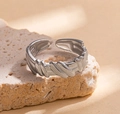 Silver open ring with unique irregular texture on a beige stone platform - Steel Color 14-3