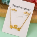 Set gioielli dorati in acciaio inossidabile con freccia di Cupido e cuore su carta bianca - Set Freccia del Cuore
