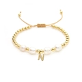 Detailed macro view of an 18K gold bead bracelet with natural pearls and a letter N pendant - Letter N