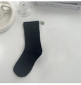 Minimalistische schwarze Baumwollsocke flach liegend mit ästhetischen Requisiten - Schwarz