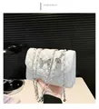 Detail of white quilted crossbody bag with silver bow ornament and elegant chain strap - White