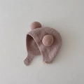 Detailed close-up of baby earflap hat in dusty pink featuring plush pom poms and button strap - Earflap Hat / Plush Ball [Mocha]