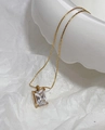 Macro detail of rectangle emerald-cut green zircon pendant on 18k gold plated chain - Square Zirconia Necklace / White/Clear
