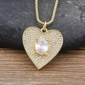 Exquisite goldene Herz-Halskette mit ovalem Zirkon auf einer dunklen Steinbasis - Weiß