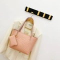 Pink quilted tote bag with matching pouch and gold hardware hanging on a suit - Pink