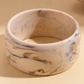 Macro shot of wide marble-patterned resin bangle with warm beige and brown tones - Retro Matte Texture / Grey Blue Marble