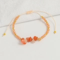 Detailed close-up of handmade Bohemian beaded bracelet with orange stones and gold spacers - Pink Aventurine
