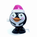 Cute wind-up penguin toy with pink Santa hat walking on white background - New Designs Penguin