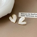 Close-up of heart-shaped pearl earrings with gold edges on an elegant background - Pearly White Heart Gold Edge