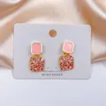 Macro di orecchini a perno quadrati in smalto rosa con cristalli su sfondo di seta - Orecchini Quadrati in Zirconia Rosa