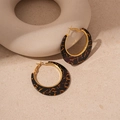 Close-up of tortoise shell resin hoop earrings with gold texture on beige background - Silver Needle Black Hoop