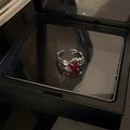 Minimalist silver ring featuring a red gemstone with unique lava texture on a black display - Red Rhinestone Style (红宝石戒指)