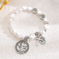 Detailed close-up of religious heart pearl bracelet with Saint Benedict medal charms - Antique Silver (M-549)