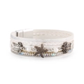 Detailed macro view of white leather ocean bracelet with sea turtle and starfish charms - White