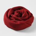 Deep red cotton linen scarf rolled into a rose flower shape on a white background - Burgundy