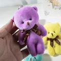 Close-up of a purple plush teddy bear keychain with a Love ribbon and silver ring - Bright Purple