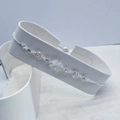 Elegant silver clover bracelet featuring cat eye stones and shiny zircons on a white stand - Silver