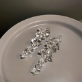 Detail of irregular acrylic ice cube earrings featuring a clear aesthetic and vintage drop style - Clear