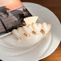 Beige macaron heart hair claw clip with four white hearts on a ceramic plate - Beige