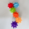 Rainbow plastic gears for busy board featuring red, blue, and purple rotating wheels - Single Gear Accessory