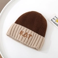 Dettaglio di un berretto in maglia bicolore con ricamo NOT e trama a coste verticali - Solo Cappello / caffè
